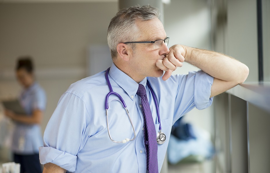 5thPort – Healthcare Doctor Burnout – Panel 3 An exhausted doctor looks out of the window in a hospital. With 5thPort's digital and electronic informed consent process, this kind of clinician burnout can be greatly reduced.